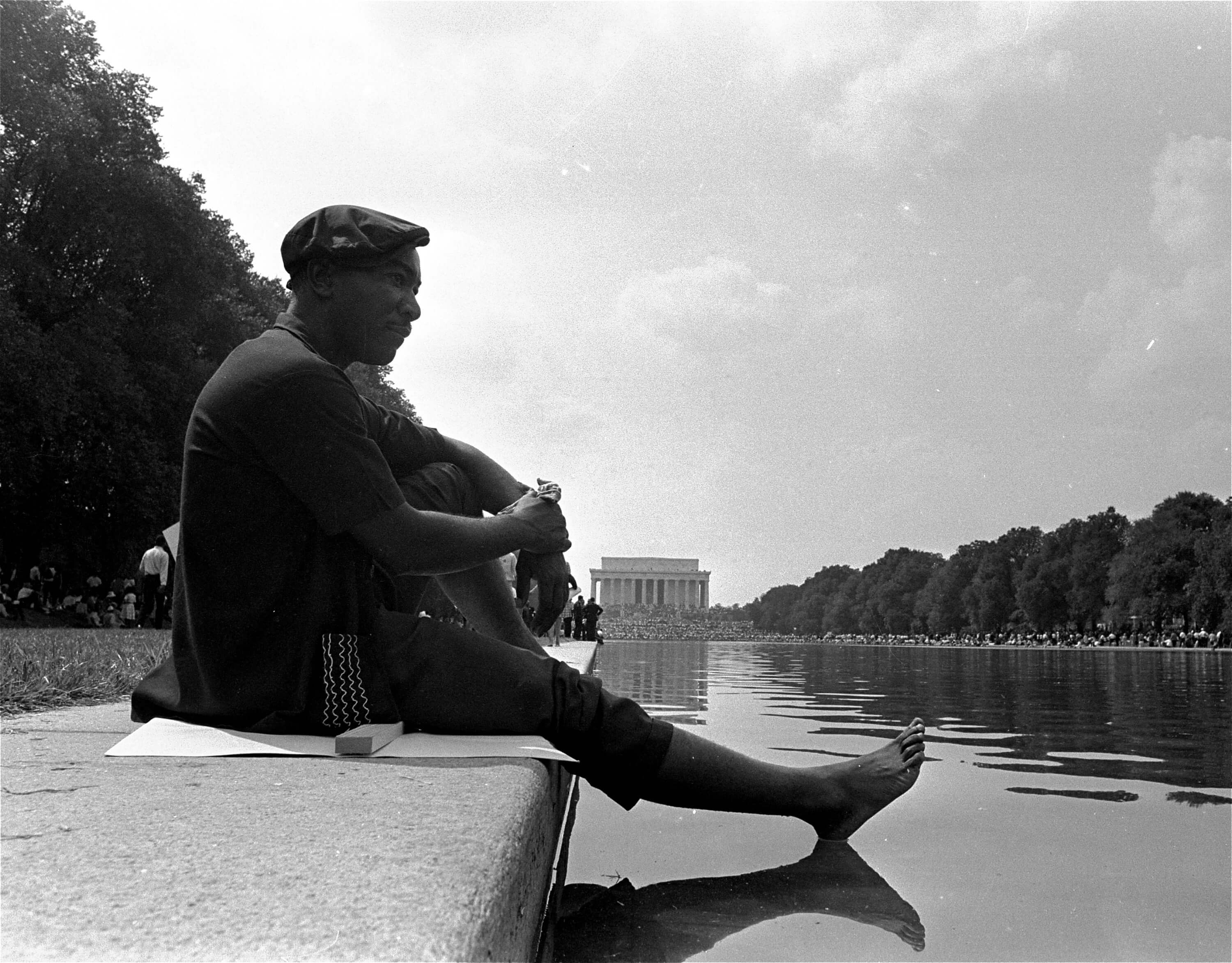A civil rights marcher cools off his bare foot on the surface of the reflecting pool near the Lincoln Memorial following the March on Washington for Jobs and Freedom, August 28, 1963. (AP Photo)