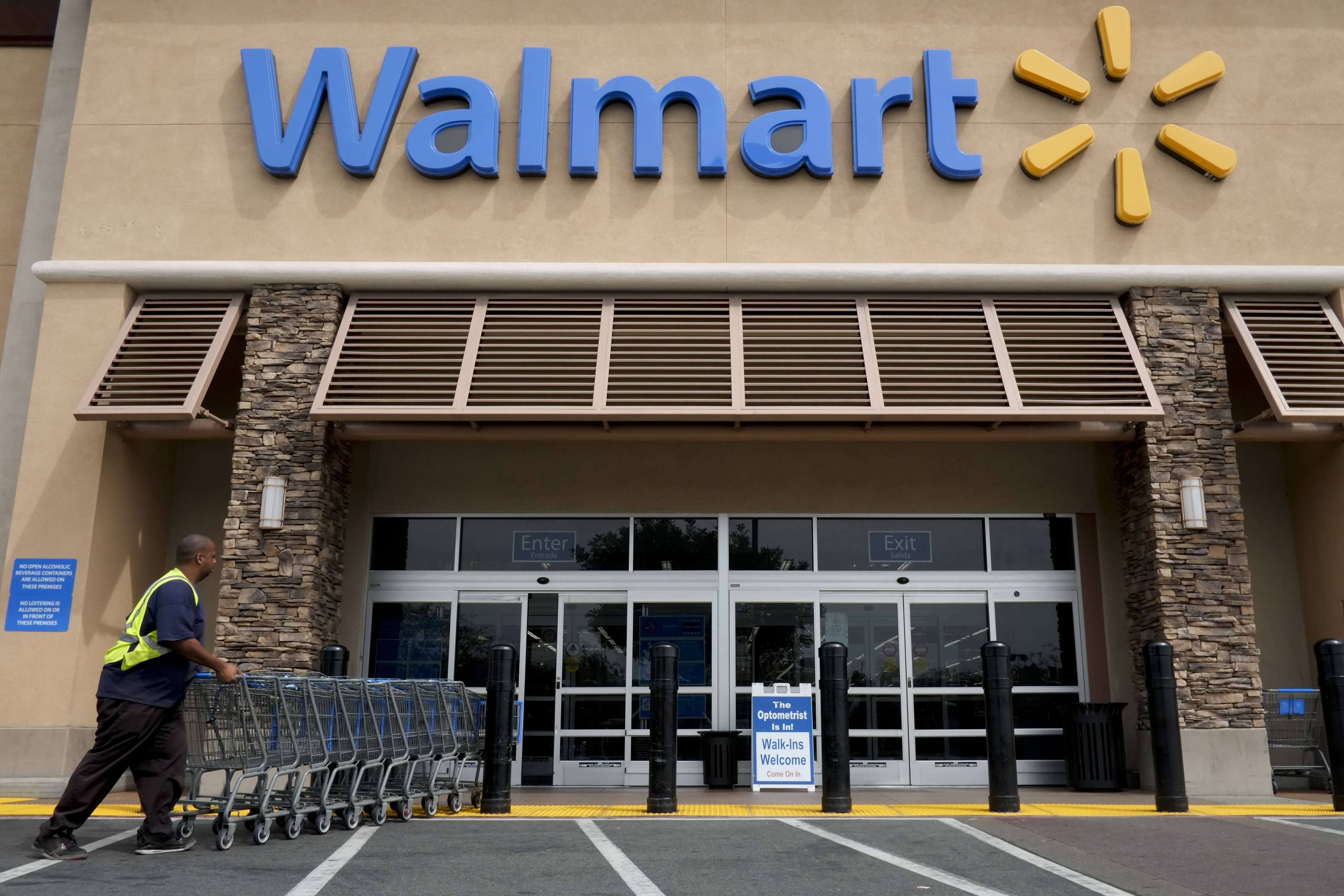 A worker pushes shopping carts in front of a Wal-Mart store in La Habra, California. (AP Photo/Jae C. Hong, File)