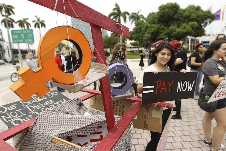 Several women stage a protest in downtown Miami demanding equal pay for women.
