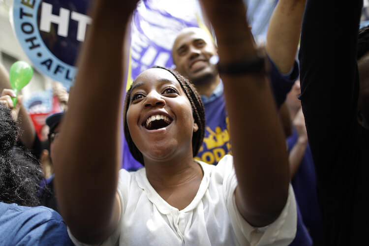 An activist cheers at a minimum wage rally in New York. Given the slow productivity growth, some economists are wondering if higher wages might increase productivity. 