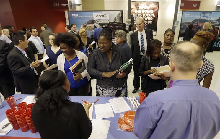 In this photo taken Wednesday, June 10, 2015, job seekers attend a job fair in Sunrise, Fla.