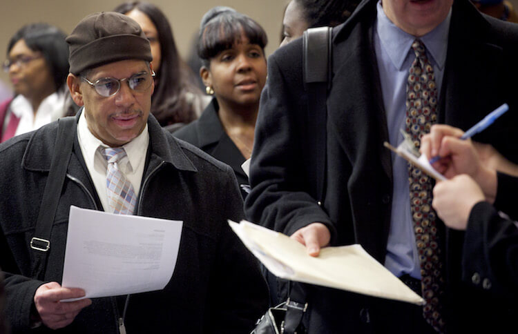 People wait to talk with potential employers at a job fair in New York.