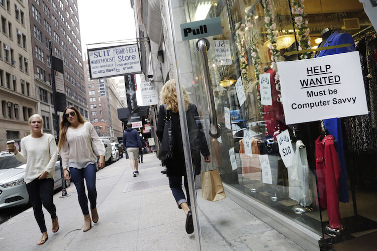 A “Help Wanted” sign hangs in a store window in New York. While the labor market is getting stronger, most measures indicate that labor market slack still remains.