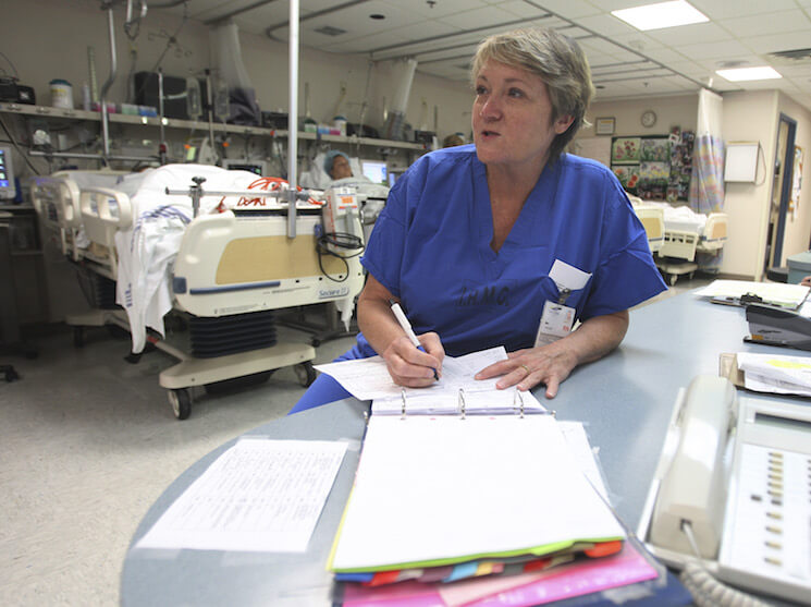 Nurse Mary Pitman checks a patient’s chart at the Indian River Memorial Hospital recovery room in Vero Beach, Fla.