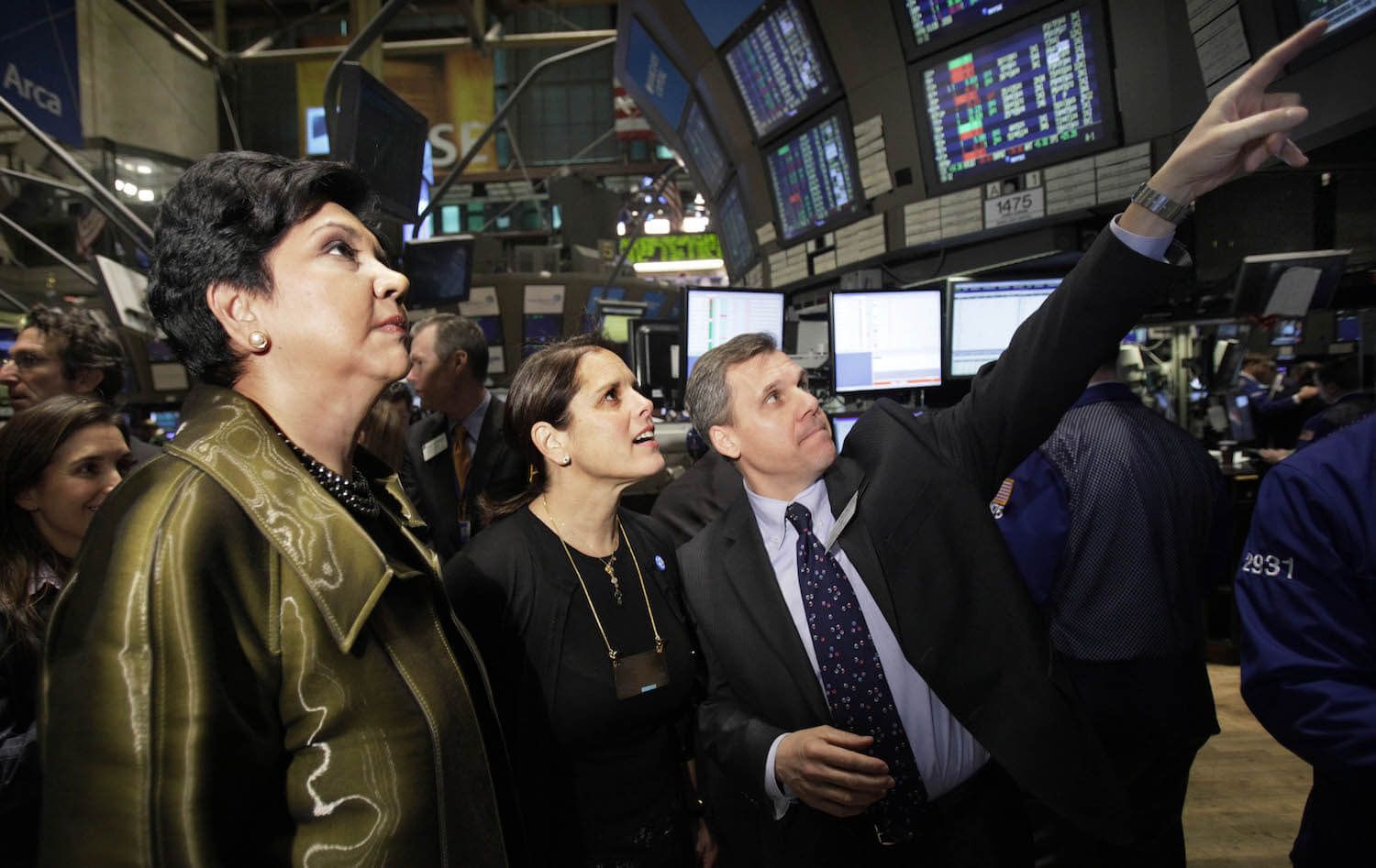 PepsiCo Inc. chairman and chief executive Indra K. Nooyi, left, and Jill Beraud, PepsiCo president of sparkling brands, meet with Barclays Capital investor relations representative Carmen Barone, right, at the post that trades Pepsi on the floor of the New York Stock Exchange Monday, Feb. 1, 2010. (AP Photo/Richard Drew)