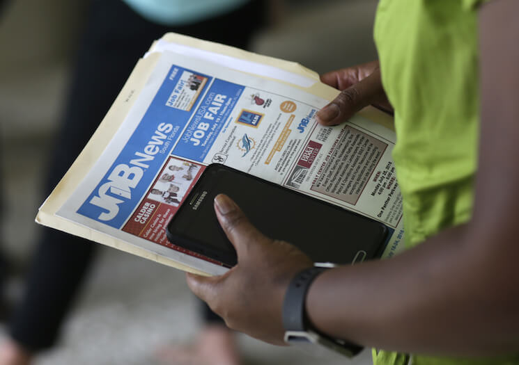 In this Tuesday, July 19, 2016, photo, a job applicant attends a job fair in Miami Lakes, Fla. 