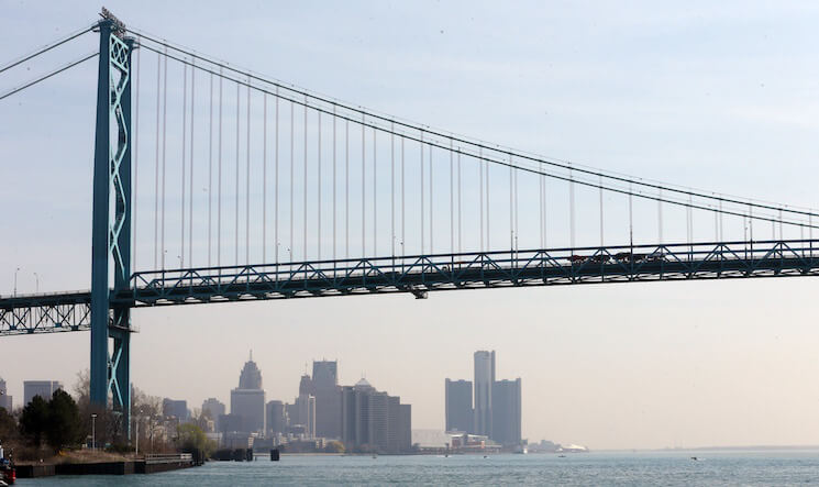 The Detroit skyline is seen under the Ambassador Bridge.