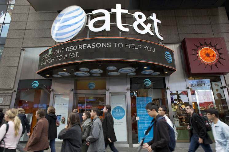 People walk by an AT&T retail store, Monday, Oct. 24, 2016, in New York. AT&T plans to buy Time Warner for $85.4 billion.