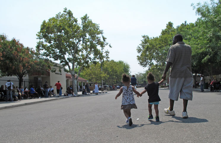 A man walks with two children in Fresno, Calif. 