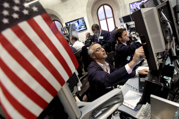 Traders work in a booth on the floor of the New York Stock Exchange. 