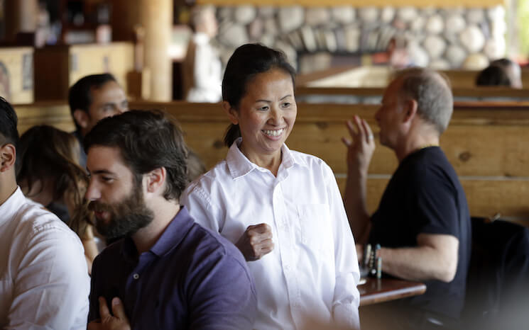 A server smiles as she talks with customers at a Seattle restaurant.