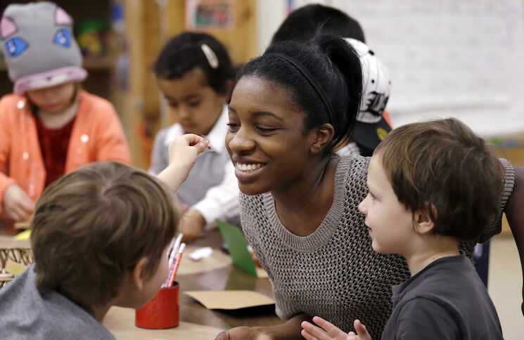 In this photo, assistant teacher D'onna Hartman smiles as she works with children at the Creative Kids Learning Center in Seattle.