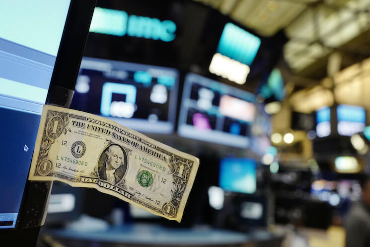 A stock trader has taped a one dollar bill to his computer screen at the New York Stock Exchange. 