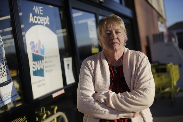 Terry Work stands outside a store that accepts food stamps in Tennessee. Work's 27-year-old deaf son recently was denied disability payments. 