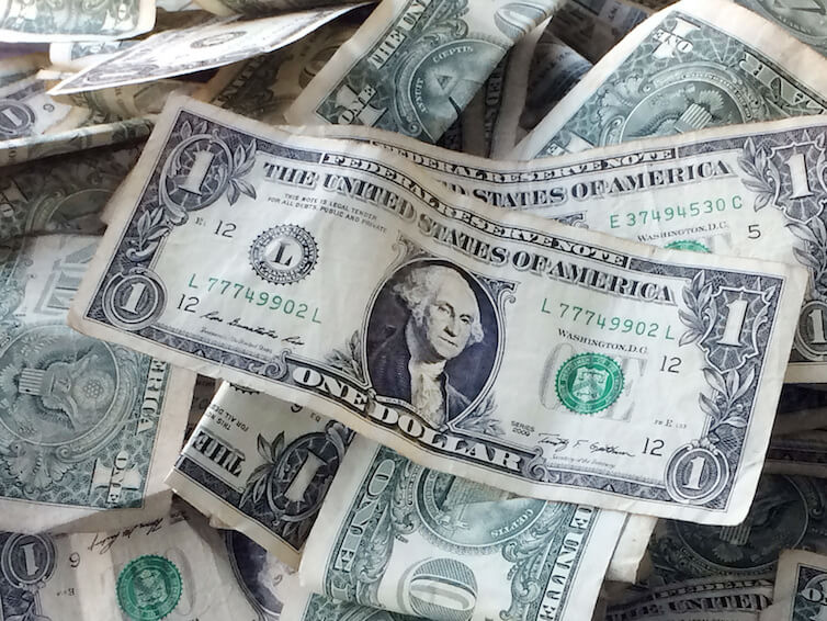 One dollar bills in a tip jar at a car wash in Brooklyn, NY.