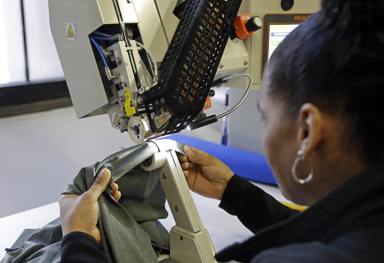 A woman works with fabric at 99Degrees Custom in Lawrence, Massachusetts.