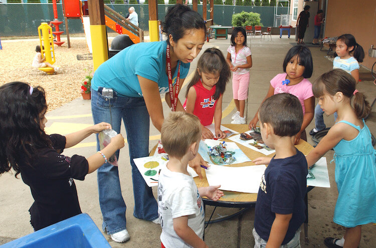 Teacher Margarita Hernandez, second left, leads a group of preschoolers with an outdoor art project at a Head Start Program in Hillsboro, Ore. 