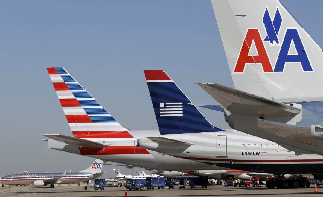 US Airways and American Airlines planes are shown at gates at Dallas/Fort Worth International Airport, February 14, 2013, in Grapevine, Texas.