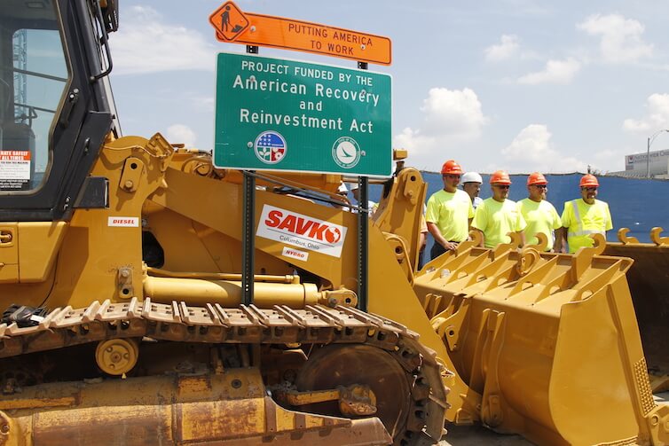 Construction workers look at a highway road project funded by the American Recovery and Reinvestment Act in Columbus, Ohio.