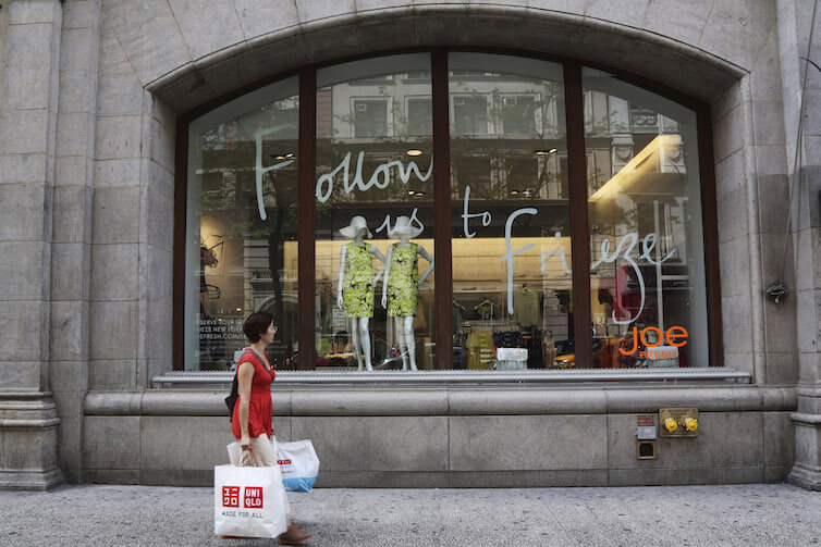 A shopper walks past a store on Fifth Avenue in New York.