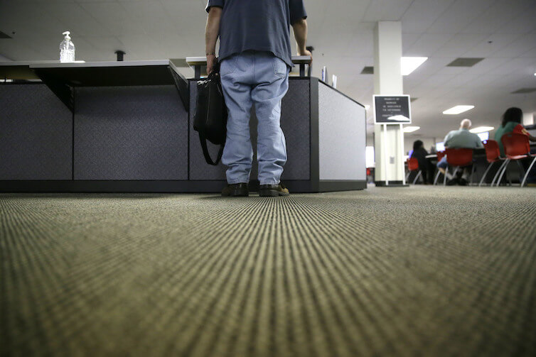 A lone job seeker checks in at the front desk of the Texas Workforce Solutions office in Dallas.