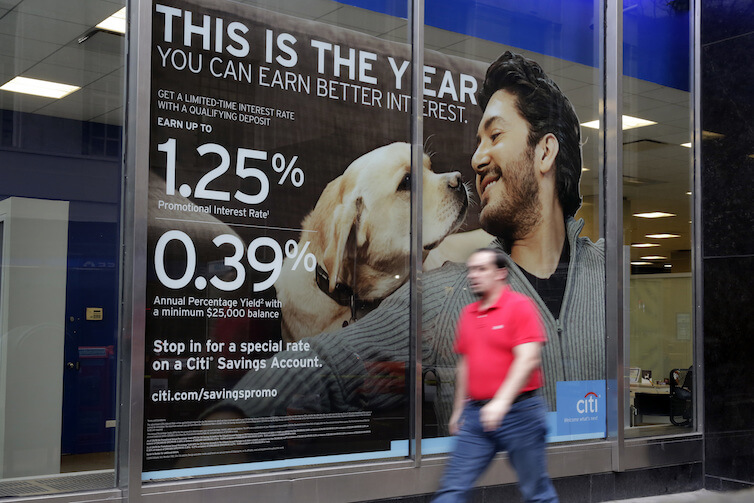 A sign in the window of a Citibank branch in New York shows savings account rates. Secular stagnation, or the consequences of an economy with a long-term excess supply of desired savings over desired investment, requires new macroeconomic solutions that will help alleviate negative effects during the next economic downturn.