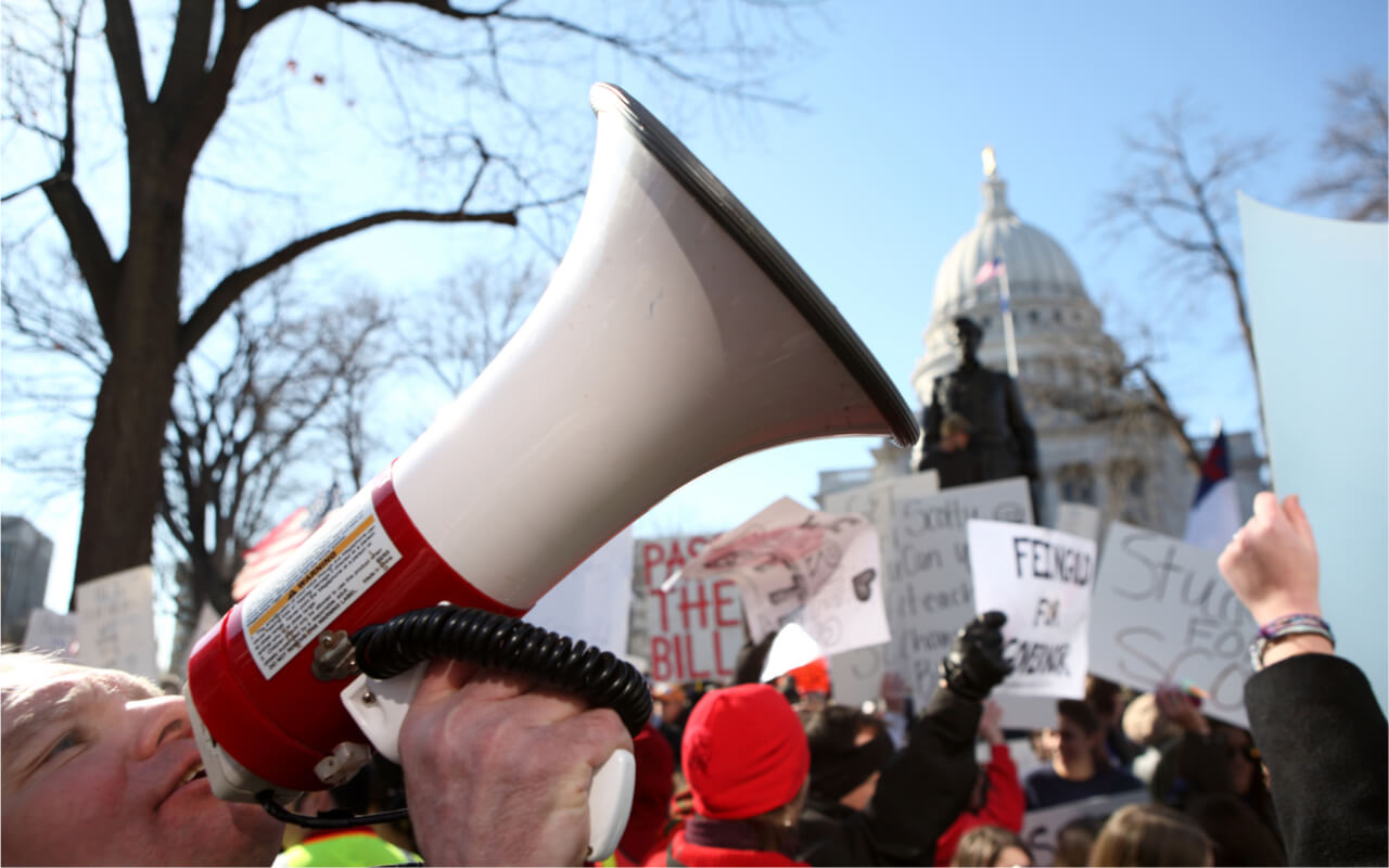 Opponents and supporters of former Gov. Scott Walker's bill to take away public worker bargaining rights chant slogans and carry signs on February 19, 2011 in Madison, Wisconsin.