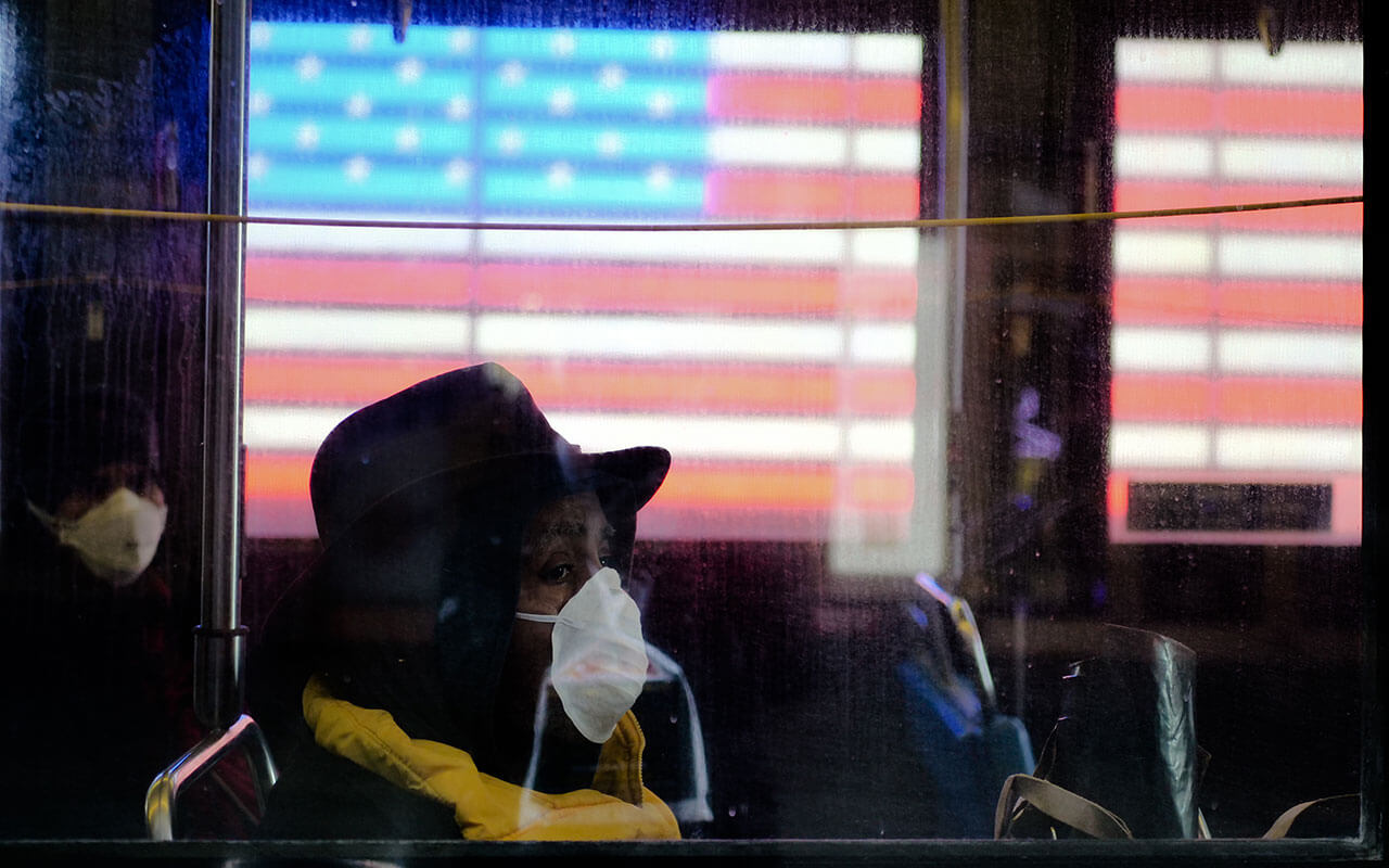 Conducteur de bus regarde par la fenêtre lors d'un trajet à travers Times Square à New York en mars.